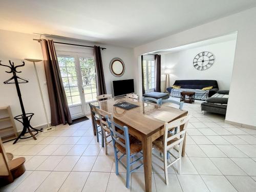 un salon avec une table et un canapé dans l'établissement Villa 5 pièces avec jardin, à 400m de la plage et 600m des commerces, wifi et barbecue inclus - FR-1-361-20, à Jullouville