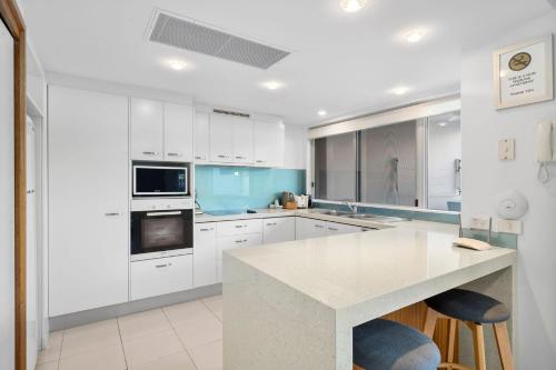 a kitchen with white cabinets and a white counter top at Unit 30-31 12 Perry Street in Coolum Beach