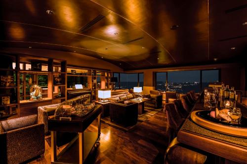 a restaurant with tables and chairs and a view of a city at Hotel Grand Bach Atami Crescendo in Atami