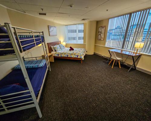 a dorm room with bunk beds and a desk at Choice Backpackers in Auckland