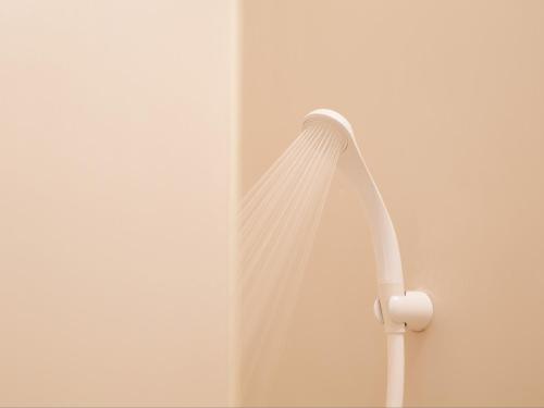 a white shower curtain hanging on a wall at Tabist A Mirai Oji in Tokyo