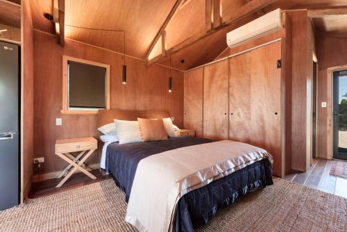 um quarto com uma cama e uma televisão em The Shed Guest House em Mount Maunganui