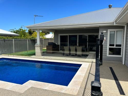 a swimming pool in front of a house at Sunsets by the Lake in Yarrawonga