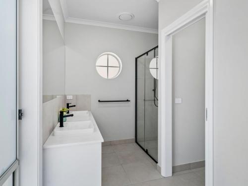 a white bathroom with a sink and a shower at Sunsets by the Lake in Yarrawonga