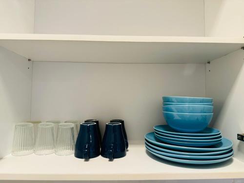 a shelf with blue plates and a blue bowl at Arte Plus KL By Rainbow in Kuala Lumpur