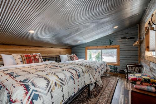 a bedroom with two beds in a log cabin at Bunkhouse in West Yellowstone