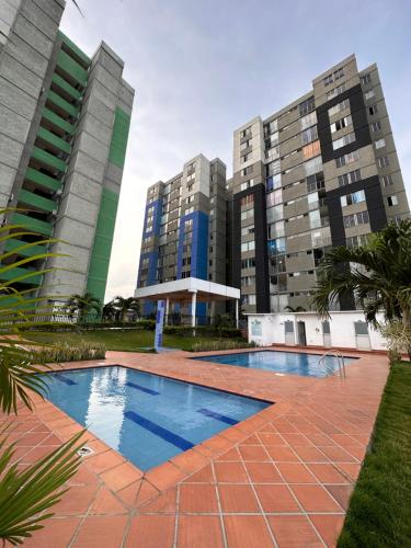 a swimming pool in front of two tall buildings at Apartamento cerca al aeropuerto BILBAO in Cúcuta