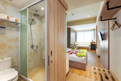 y baño con cama y ducha. en Boss Legian Hotel Powered by Archipelago en Legian