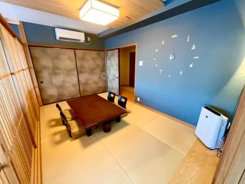 a room with a table and a blue wall at 【CLUB DEEP BLUE】西伊豆　知る人ぞ知る美しい入江が眺める貸別荘！最大44人宿泊可能！ in Numazu
