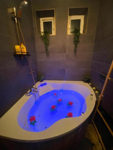 a bathroom with a tub with flowers in it at Exotic spa in Poissy