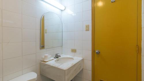 a bathroom with a sink and a mirror at Aloha Hotel Roxas Boulevard Manila in Manila