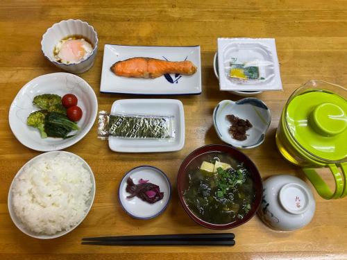einem Holztisch mit Teller mit Lebensmitteln darauf in der Unterkunft Business Hotel Shizusato Ryokan in Ōgaki