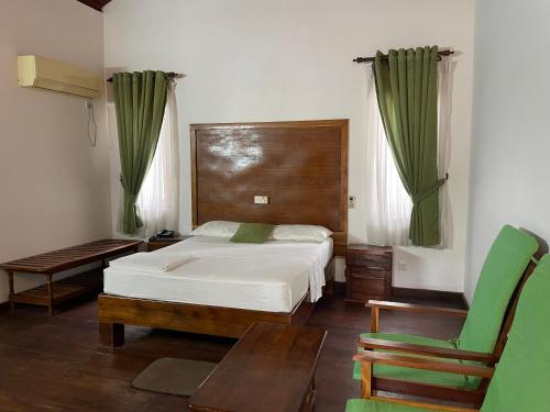 1 dormitorio con 1 cama, 1 mesa y 1 silla en Hotel Neithal Batticaloa, en Batticaloa