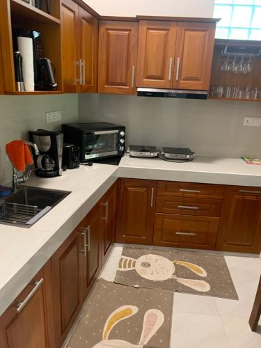 a kitchen with wooden cabinets and a kitchen rug on the floor at Wasa Villa in Kalutara