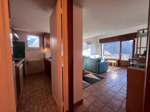 a room with a kitchen and a living room with a couch at Appartement La Clusaz, 3 pièces, 6 personnes - FR-1-437-108 in La Clusaz
