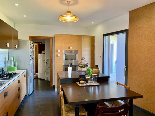 uma cozinha com uma mesa de madeira e uma sala de jantar em Résidence Guddelmoni em Propriano