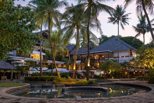 a resort with a pool in front of a building at Turi Beach Resort in Nongsa