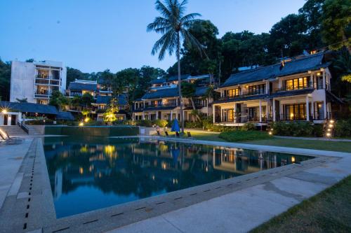 a house with a swimming pool in front of a building at Turi Beach Resort in Nongsa