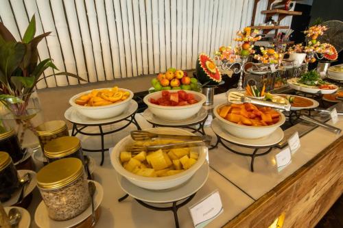 a buffet with bowls of fruit on a table at Turi Beach Resort in Nongsa