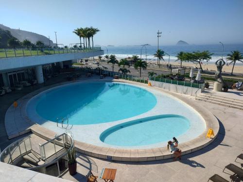 a large swimming pool next to a beach at Hotel Nacional in Rio de Janeiro