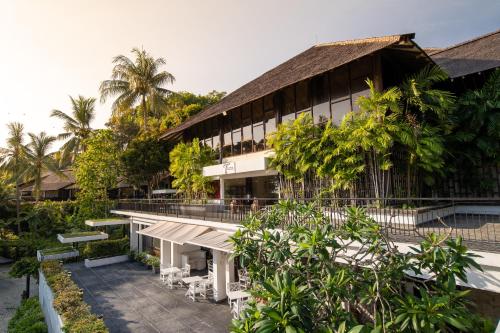 an exterior view of a building with trees at Turi Beach Resort in Nongsa