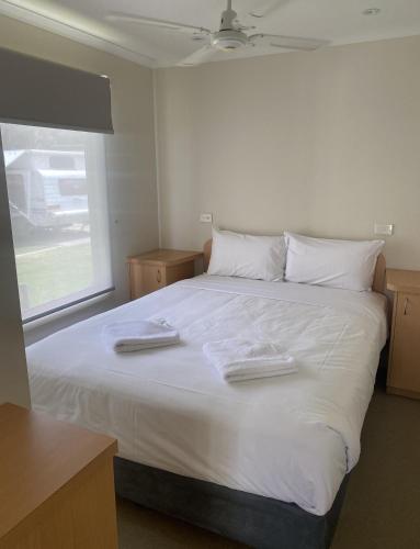 a bedroom with a large white bed with two towels on it at BIG4 Moama Holiday Park in Moama