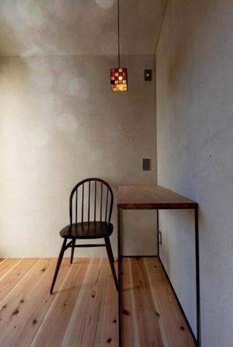 a chair sitting next to a table in a room at 暮らすように過ごすNagi unoport in Uno