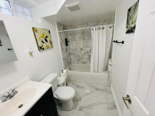 a white bathroom with a toilet and a sink at DIAMOND PLACE in Brampton