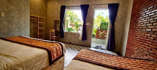カントーにあるSong Ngư Pisces Homestayのレンガの壁、ベッド2台が備わるベッドルーム1室が備わります。