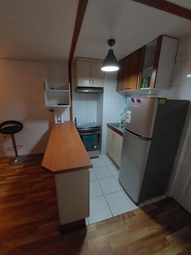 a kitchen with a refrigerator and a table in it at Edificio Plaza Las Palmas 1006 in Iquique