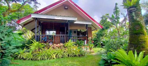 a small house in the middle of a garden at JHULLIE’S BREEZY HUT in Tagaytay