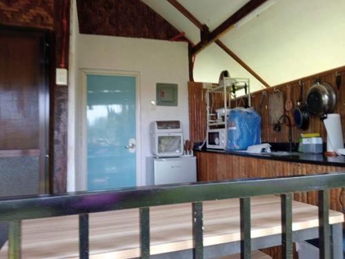 a kitchen with a counter top and a refrigerator at JHULLIE’S BREEZY HUT in Tagaytay