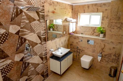 La salle de bains est pourvue d'un lavabo et de toilettes. dans l'établissement Lumbini Five Elements Hotel, à Rummindei