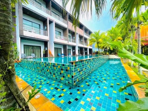 a swimming pool in front of a building at Rimnatee Resort Trang in Trang