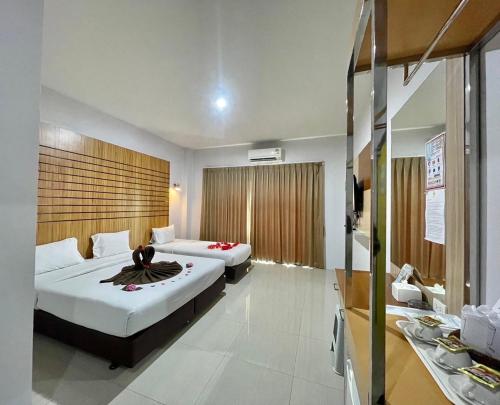 um quarto de hotel com duas camas e uma casa de banho em Rimnatee Resort Trang em Trang