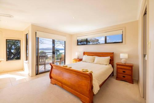 - une chambre avec un grand lit et un balcon dans l'établissement Unwind @Hawley Beach, à Hawley Beach