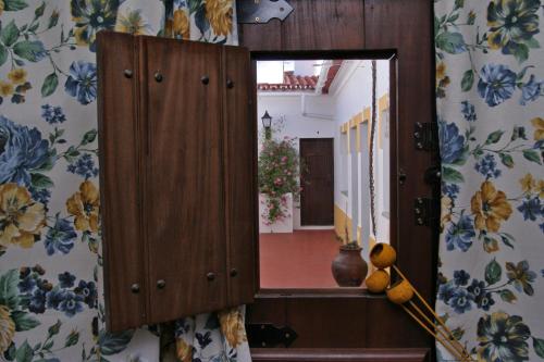 a mirror in a room with flowers on the wall at Alojamento Pero Rodrigues in Alandroal