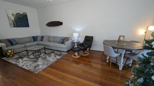 een woonkamer met een bank en een tafel bij Hatbox House in Perth