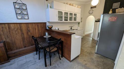 a kitchen with a table and a refrigerator at Hatbox House in Perth