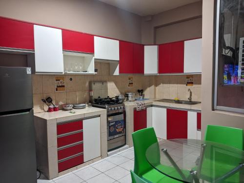 プカルパにあるDEPARTAMENTOS SUCRE PCLのキッチン(赤と白のキャビネット、電化製品付)
