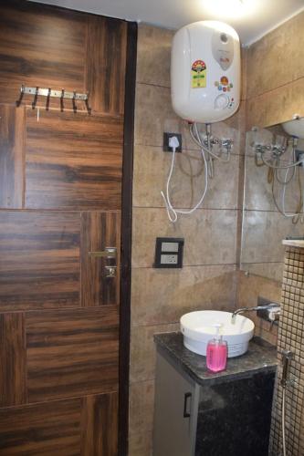 a bathroom with a wooden door and a sink at 2BHK luxury Escape in rishikesh in Rishīkesh
