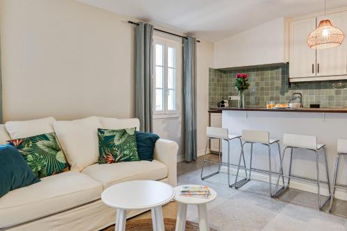 un salon avec un canapé et une cuisine dans l'établissement Appartement des Trésoriers - Welkeys, à Montpellier
