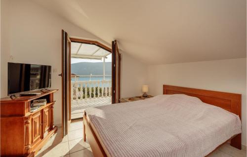 Schlafzimmer mit einem Bett, einem TV und einem Balkon in der Unterkunft Amazing Apartment In Herceg Novi With Kitchen in Herceg-Novi
