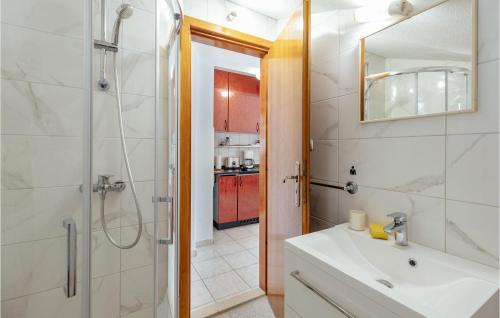 ein Bad mit einer Dusche, einem Waschbecken und einer Dusche in der Unterkunft Amazing Apartment In Herceg Novi With Kitchen in Herceg-Novi