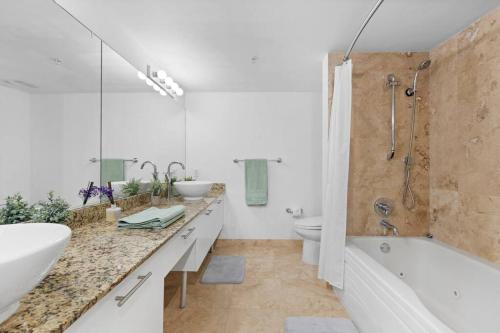 uma casa de banho com 2 lavatórios, uma banheira e um WC. em Stylish 3 bed/2 bath 2 story em Miami