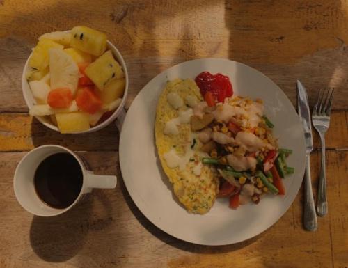 a plate of breakfast food with a cup of coffee at JEJU Cottages in Kuta Lombok
