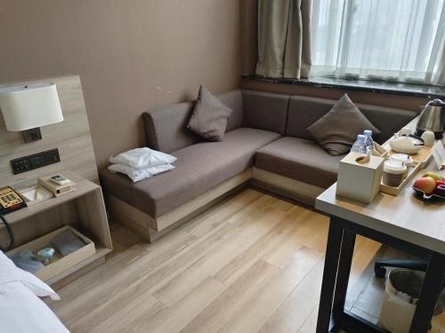a small living room with a couch and a table at Atour Hotel Hefei Ma'anshan Road in Hefei