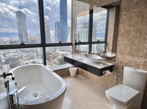 a bathroom with a tub and a sink and a toilet at Dorsett Residences Bukit Bintang in Kuala Lumpur