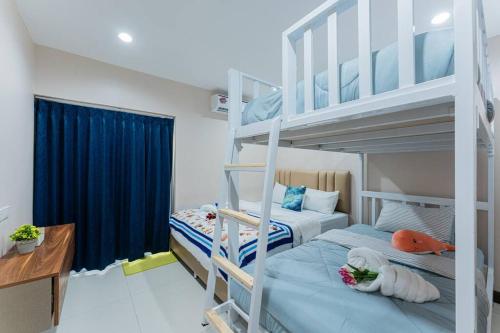 a bedroom with two bunk beds and a desk at Ocean Pool Villa Pattaya in Bang Sare