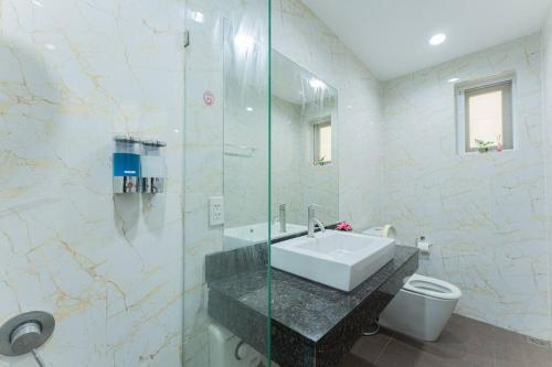 a bathroom with a sink and a glass shower at Ocean Pool Villa Pattaya in Bang Sare